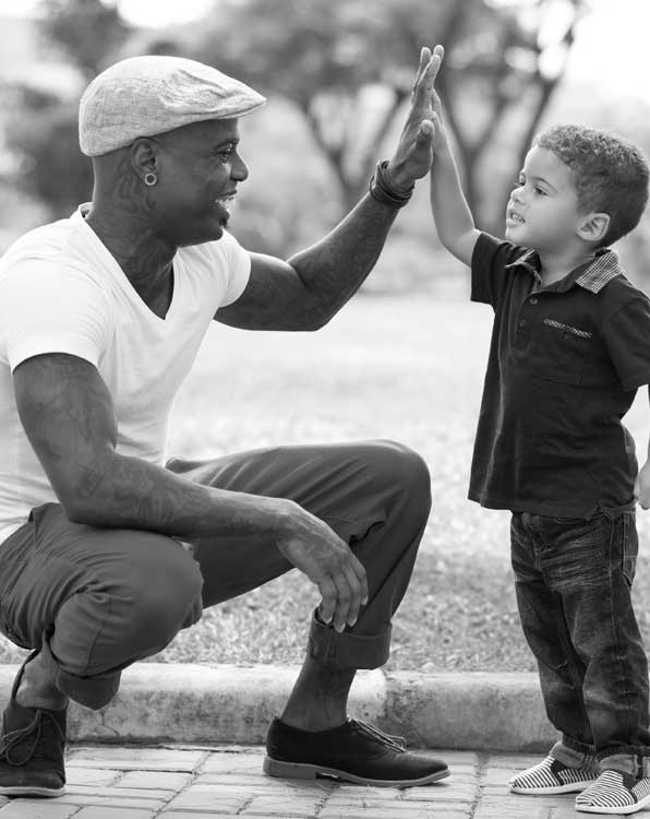 A man and boy giving each other a high five.